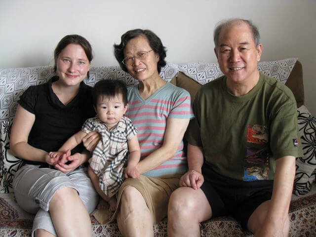 Student and host family sitting together at a sofa