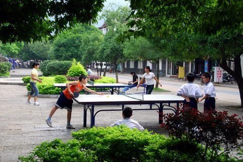 Several people playing ping pong outside in Beijing